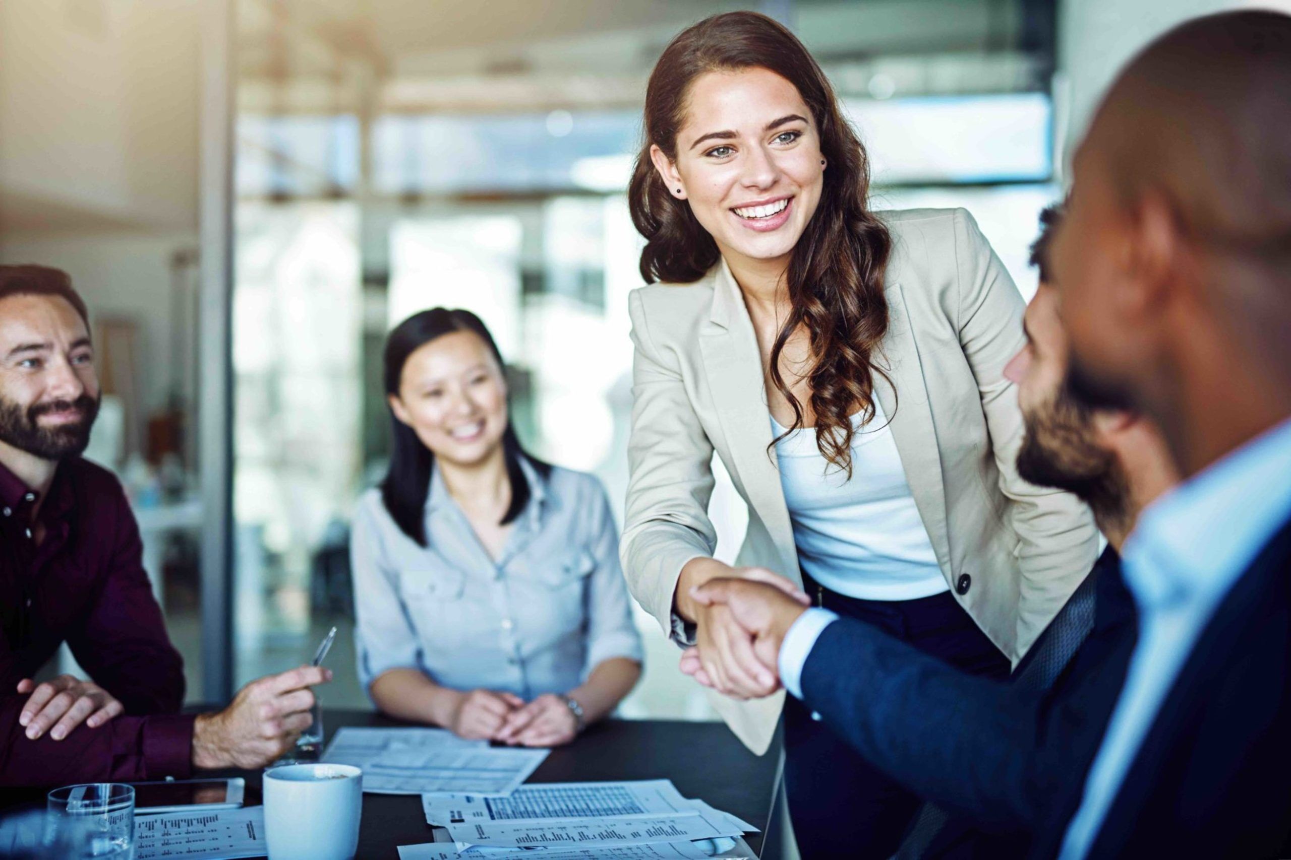 Women completing a successful negotiation and shaking hands with a client.